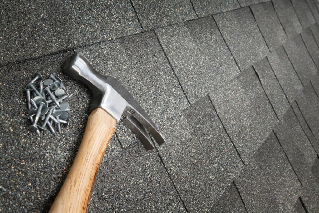 A Texas Direct Roofing technician repairing shingles on a roof